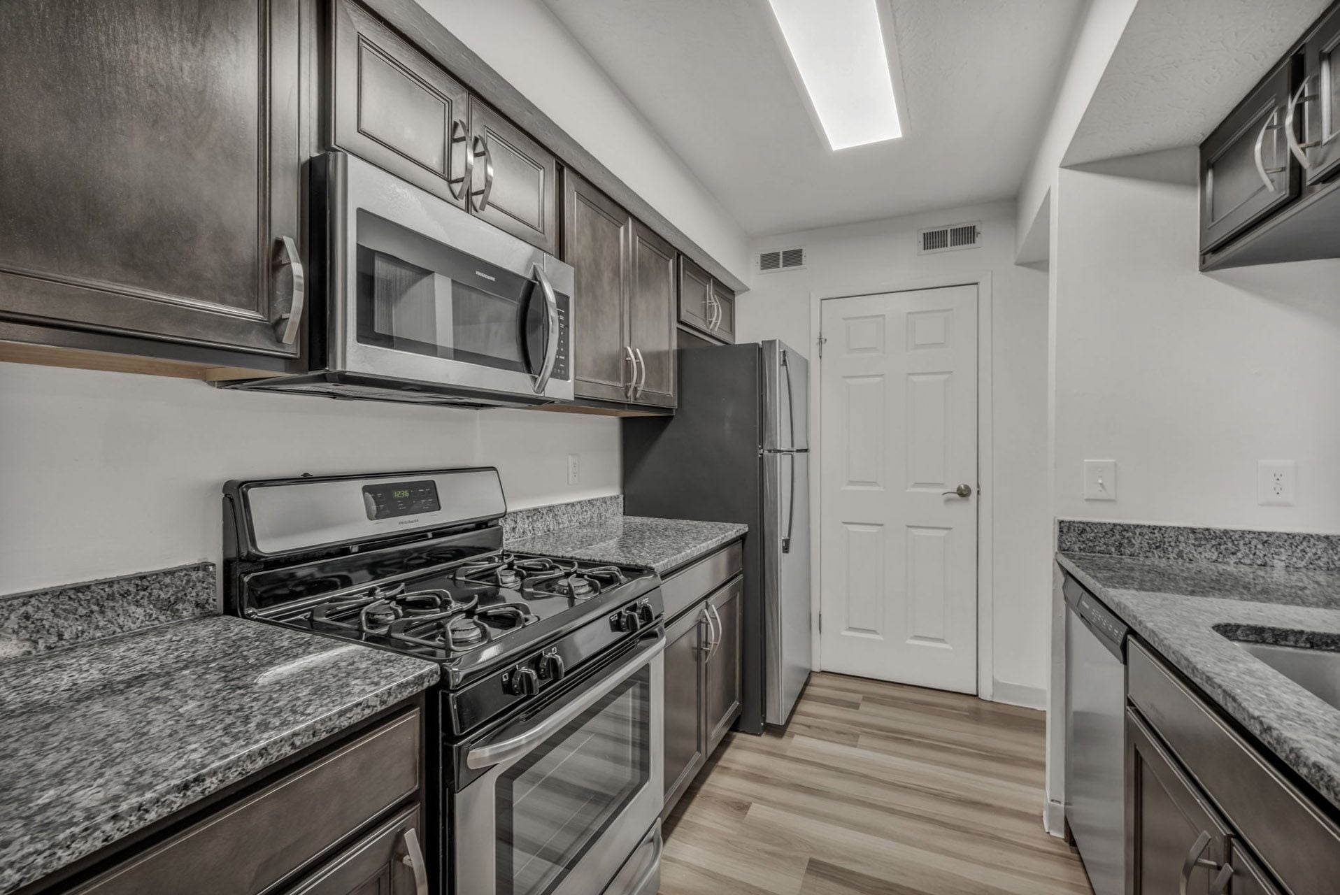 Gold finish kitchen with stainless steel appliances and granite countertops.